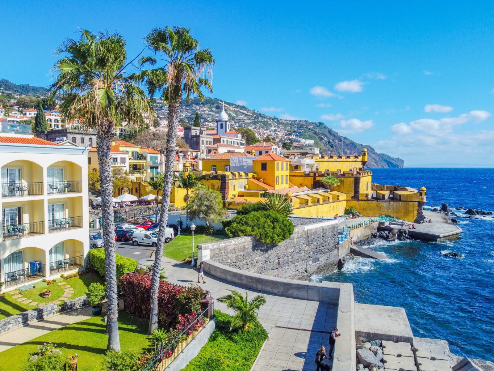 Sunny coastal view of Spain with yellow buildings and blue ocean